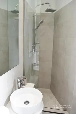 a bathroom with a shower with a toilet and a sink at Haraki Endless Blue Luxury Apartments in Haraki
