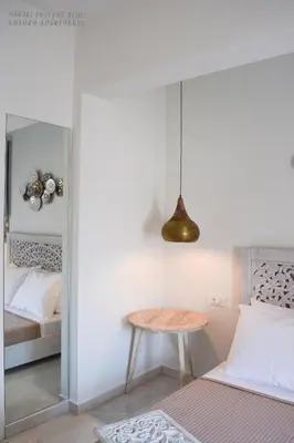 a small table in a room with a bed at Haraki Endless Blue Luxury Apartments in Haraki