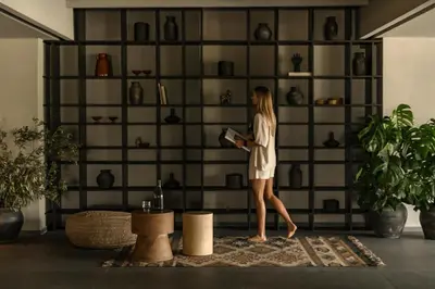 a woman walking in front of a wall of vases at Cook's Club Kolymbia Rhodes -Adults only in Kolimbia