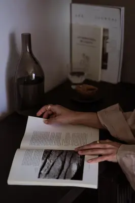 a woman is holding a book on a table at Cook's Club Kolymbia Rhodes -Adults only in Kolimbia