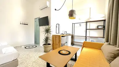 a living room with a couch and a table at Falirala Central in Faliraki