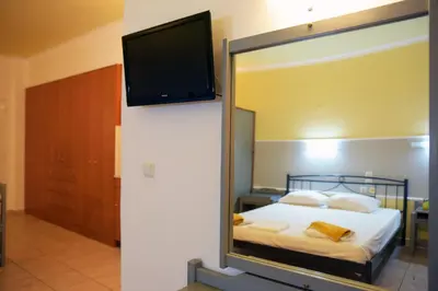 a bedroom with a bed with a mirror and a tv at Falirala Central in Faliraki