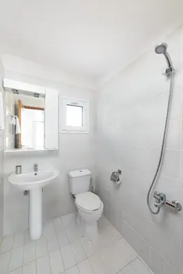 a white bathroom with a toilet and a sink at Casa Greco in Gennadi