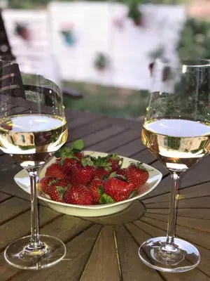 two glasses of wine and a bowl of strawberries on a table at Casa Greco in Gennadi