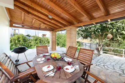 a wooden table and chairs on a patio at Casa Greco in Gennadi