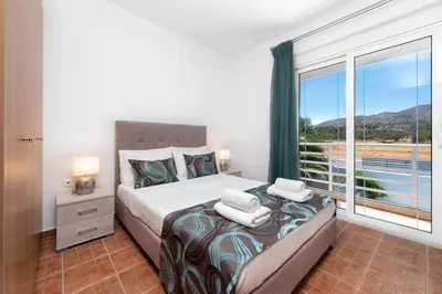 a bedroom with a bed and a large window at Casa Greco in Gennadi