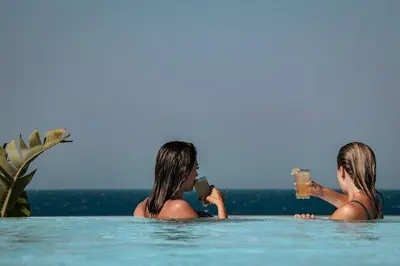two women in a swimming pool drinking drinks at More Meni City Beach Rhodes in Rhodes Town