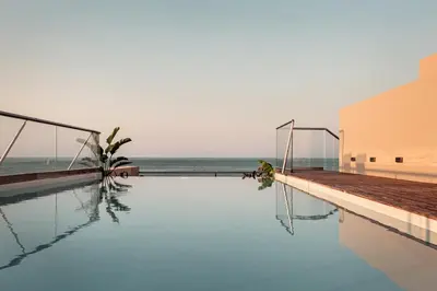 a swimming pool with the ocean in the background at More Meni City Beach Rhodes in Rhodes Town