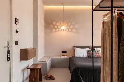 a small bedroom with a bed and a table at More Meni City Beach Rhodes in Rhodes Town