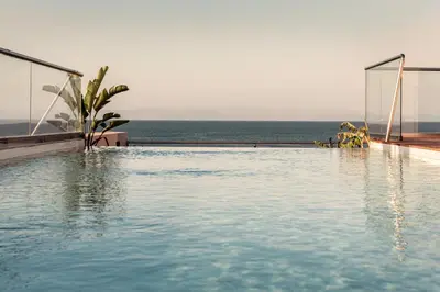 a swimming pool with the ocean in the background at More Meni City Beach Rhodes in Rhodes Town
