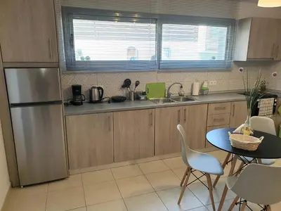 a kitchen with a stainless steel refrigerator and a table at green - comfy center rodos in Asgourou