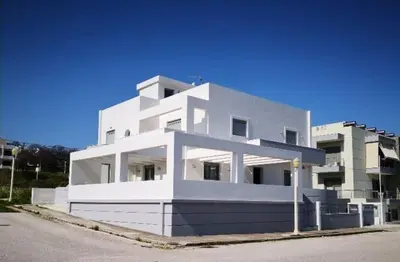 a white building sitting on the side of a street at green - comfy center rodos in Asgourou