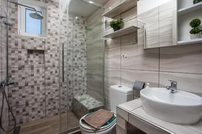 a bathroom with a shower and a sink and a toilet at Sunny Villa in Faliraki