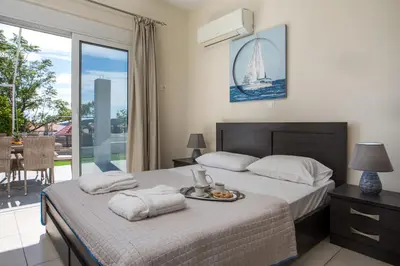 a bedroom with a large bed and a balcony at Sunny Villa in Faliraki