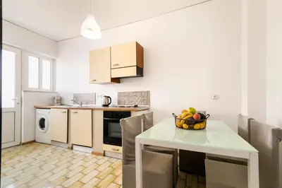 a kitchen with a table with a bowl of fruit on it at Lefka Hotel & Apartments in Rhodes Town