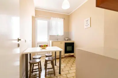a kitchen with two stools and a table in a kitchen at Lefka Hotel & Apartments in Rhodes Town