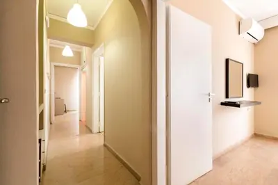 a hallway of an apartment with white walls and wooden floors at Lefka Hotel & Apartments in Rhodes Town