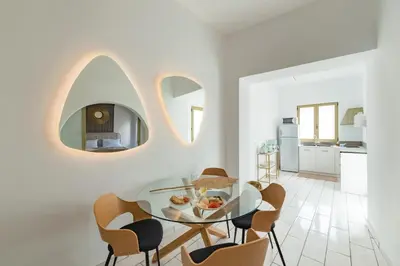 a dining room with a glass table and chairs at Lefka Hotel & Apartments in Rhodes Town