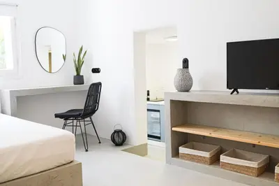 a bedroom with a bed and a tv and a chair at 30villa Rd Studio in Rhodes Town