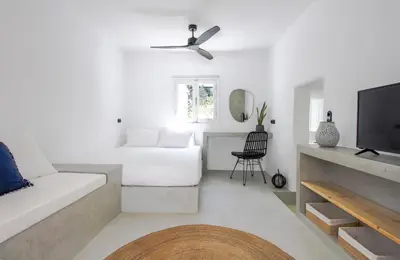 a white living room with a bed and a tv at 30villa Rd Studio in Rhodes Town