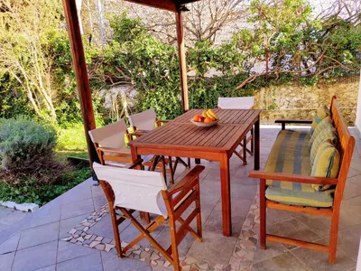 a wooden table and chairs on a patio at Villa Dalia in Archangelos