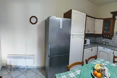 a kitchen with a refrigerator and a table with a bowl of fruit at Villa Dalia in Archangelos