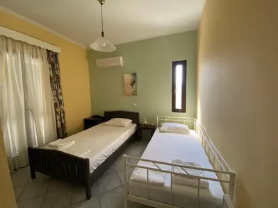 a bedroom with two beds and a window at Villa Dalia in Archangelos