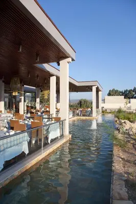 a view of a restaurant with a pool of water at Port Royal Villas and Spa - Adults Only in Kolimbia