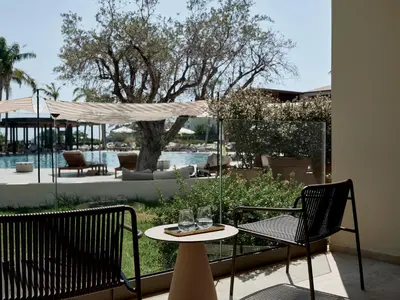 a patio with two chairs and a table with glasses on it at Port Royal Villas and Spa - Adults Only in Kolimbia