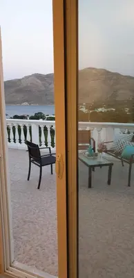 a view of a beach with a table and chairs at Nikos studios in Livadia