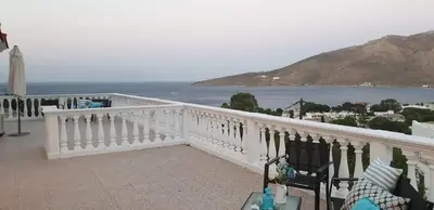 a white balcony with a view of the ocean at Nikos studios in Livadia