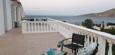 a balcony with a table and chairs and the ocean at Nikos studios in Livadia