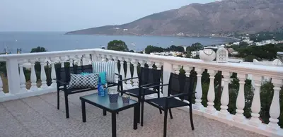 a balcony with two chairs and a table on it at Nikos studios in Livadia