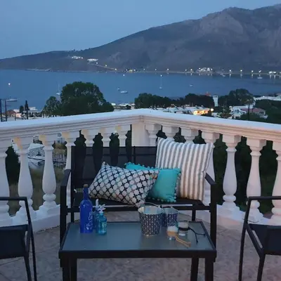 a table on a balcony with a view of the water at Nikos studios in Livadia