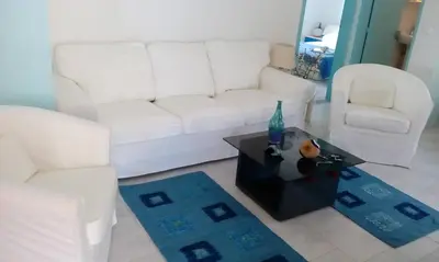 a living room with a white couch and a table at Marina Beach House in Lardos