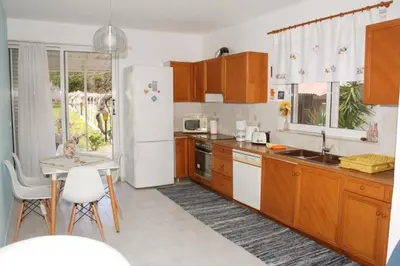 a kitchen with wooden cabinets and a white refrigerator at Marina Beach House in Lardos