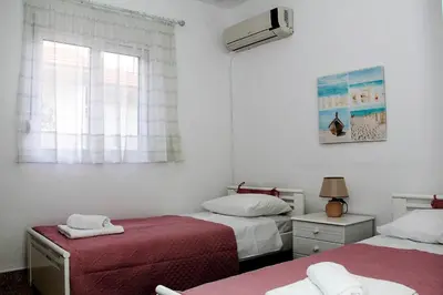 a bedroom with two beds and a window at Marina Beach House in Lardos