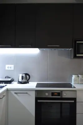 a kitchen with black cabinets and a stove top oven at Haraki Blue Pearl Luxury studio in Haraki