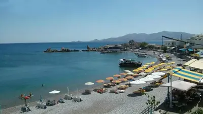 a beach with umbrellas and chairs and the water at Haraki Blue Pearl Luxury studio in Haraki