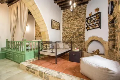 a living room with a bed and a brick wall at Traditional Stonehouse In Kalithies Village in Kalithies