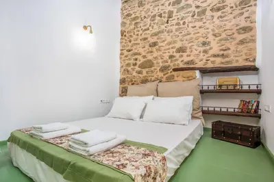 a bedroom with a bed with towels on it at Traditional Stonehouse In Kalithies Village in Kalithies