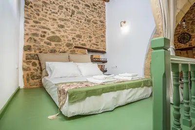 a bed in a room with a brick wall at Traditional Stonehouse In Kalithies Village in Kalithies