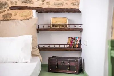 a suitcase sitting on a shelf next to a bed at Traditional Stonehouse In Kalithies Village in Kalithies
