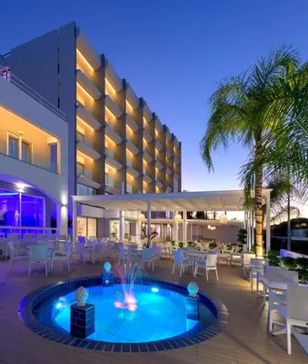 a resort with a pool and tables and chairs at Oceanis Park Hotel in Ixia