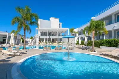 a swimming pool with chairs and a hotel at Oceanis Park Hotel in Ixia