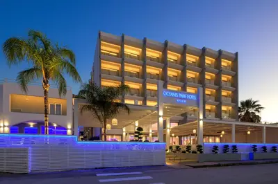a building with a palm tree in front of it at Oceanis Park Hotel in Ixia