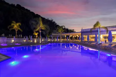 a swimming pool with purple lights in front of a building at Oceanis Park Hotel in Ixia