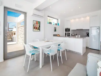 a kitchen and dining room with a white table and chairs at Villa in Rhodes near Ladiko Bay in Kalithies