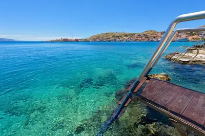 a bench on a boat in the water at Admiral's House in Halki