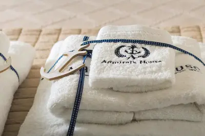 a pile of towels sitting on a bed at Admiral's House in Halki